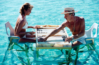 Mann und Frau spielen im Pool Backgammon Galerie Roschlaub